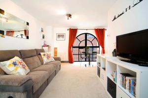 ein Wohnzimmer mit einem Sofa und einem Flachbild-TV in der Unterkunft Exclusive 1 Bed Flat Close To St Paul's Cathedral in London