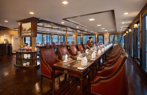 a dining room with a long table and chairs at Orchid Trendy Cruise in Ha Long