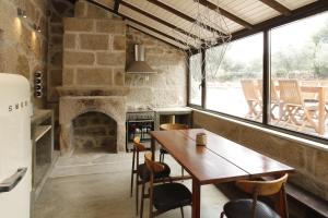 a dining room with a table and a fireplace at Casa Estrela in Juncais