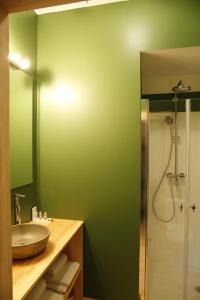 un bagno verde con lavandino e doccia di Casa Estrela a Juncais