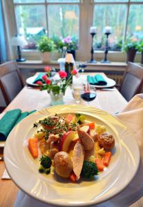 ein Teller mit Fleisch und Gemüse auf dem Tisch in der Unterkunft Haus Dumicketal in Drolshagen
