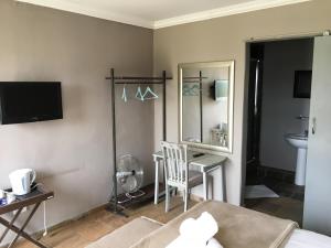 a room with a table and a chair and a mirror at Rhino Creek Estate in Bloemfontein