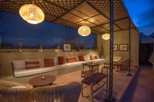 eine Terrasse mit einem Sofa, Tischen und Lampen in der Unterkunft Riad Adika & Spa in Marrakesch