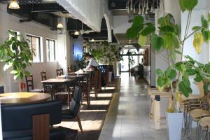 a restaurant with tables and chairs and a person in the background at Guest House M104 Kagoshima in Kagoshima