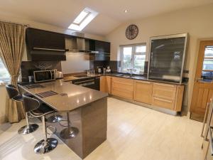 a kitchen with a counter and a clock on the wall at Shreyas Cottage in Blackburn