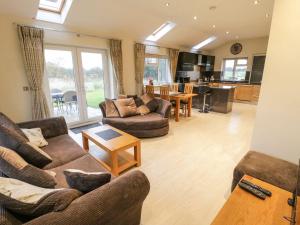 a living room with two couches and a kitchen at Shreyas Cottage in Blackburn