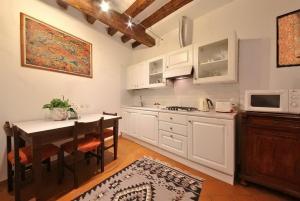 a kitchen with white cabinets and a table and a microwave at Ca Lucia in Venice