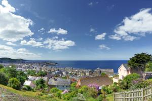 a town on a hill with the ocean in the background at Queensbridge Hotel in Aberystwyth