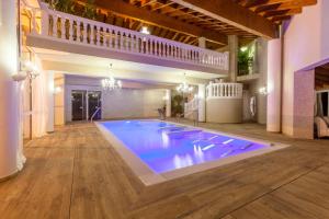 a large swimming pool in a large room with wooden floors at Hotel & SPA Bringué in Ordino