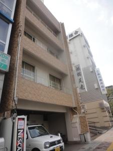廣島的住宿－天龍日式旅館，停在大楼前的白色汽车