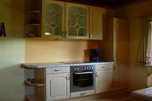 a kitchen with white cabinets and an oven at Surtmannhof in Sirnitz