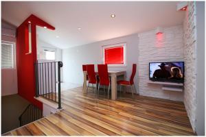 a living room with a dining room table and a tv at Apartments HULJEV in Primošten