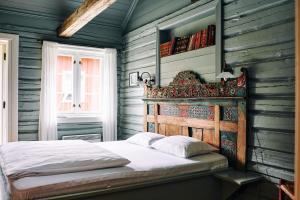 a bedroom with a bed with a wooden wall at Kleivstua Hotel near Krokskogen in Sundvollen