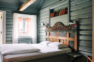 - une chambre avec un lit et un mur en bois dans l'établissement Kleivstua Hotel near Krokskogen, à Sundvollen