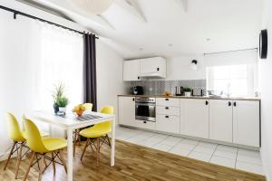 ソポトにあるStockholmのキッチン(白いキャビネット、白いテーブル、黄色い椅子付)