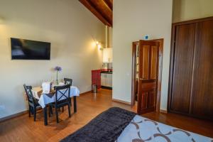 a room with a table and chairs and a kitchen at Casona de Llanorrozo Apartamentos Rurales in Oviñana