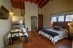 a bedroom with a bed and a table and a kitchen at Casona de Llanorrozo Apartamentos Rurales in Oviñana