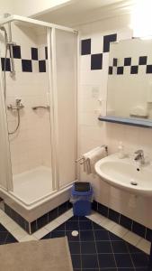 un bagno con doccia, WC e lavandino di CenterCourt Hotel a Graz