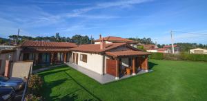 a house with a yard with a green lawn at Casona de Llanorrozo Apartamentos Rurales in Oviñana