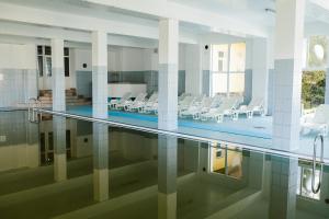 uma piscina com cadeiras e mesas num edifício em Hotel Dobsi em Bazna