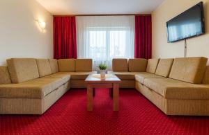 a living room with two couches and a tv at Antalya Pokoje i Apartamenty in Władysławowo