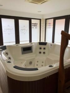 a bath tub in a room with windows at Pensiunea Ovidiu&Paula in Ibăneşti