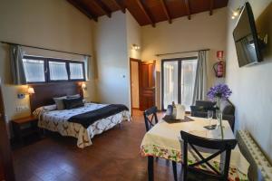 a bedroom with a bed and a table in a room at Casona de Llanorrozo Apartamentos Rurales in Oviñana