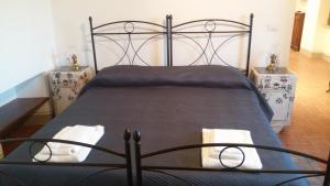 サンセポルクロにあるLa Collina di Pieroのベッドルーム1室(黒いベッド1台、ナイトスタンド2台付)