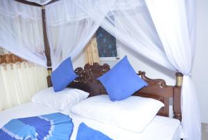 1 Schlafzimmer mit 2 Betten und blauen Kissen in der Unterkunft Star Nodes Villa in Galle