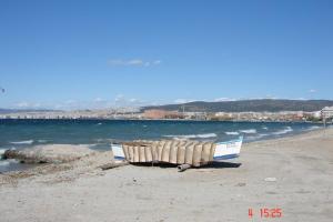 a boat sitting on a beach next to the water at Private Room In a Shared Flat in Thessaloniki