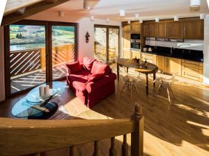 salon z czerwoną kanapą i stołem w obiekcie Apartamenty Bawaria w Szklarskiej Porębie