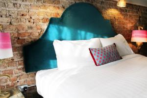 a bedroom with a bed with a green headboard and two lamps at House Bedrooms Dublin in Dublin