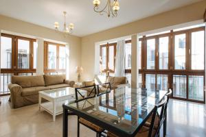 a living room filled with furniture and a large window at AT apartamentos & VTV Conde de Torrejón 10 in Seville