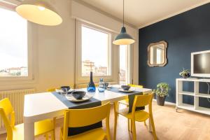 a dining room with a white table and yellow chairs at Casa Stretti by Welc(H)ome in Treviso