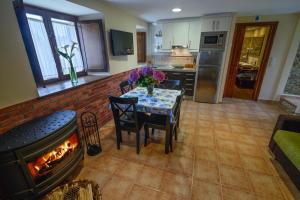 a kitchen and dining room with a table and a fireplace at Casona de Llanorrozo Apartamentos Rurales in Oviñana
