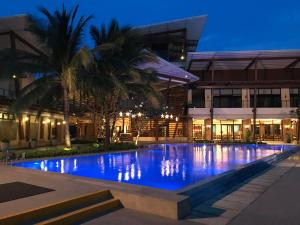 Creys condo at Pico de Loro Cove في ناسوغبو: مسبح امام مبنى في الليل