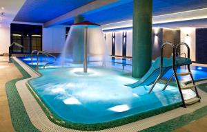 a pool with a water slide in a hotel room at Hotel Młyn Aqua Spa Biblioteka in Elblag