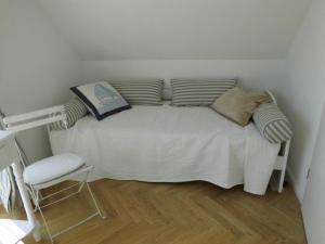uma cama com almofadas e uma cadeira num quarto em Ferienwohnung Ferienhaus Hohwachter Bucht Ostsee DSL WLAN em Hohwacht