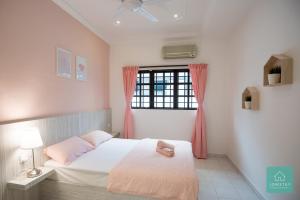 um quarto com uma cama e uma janela com cortinas cor-de-rosa em Jomstay Pink House Ipoh em Ipoh