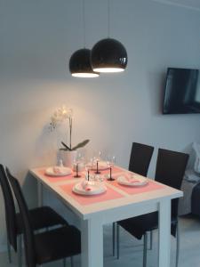 een eettafel met een witte tafel met stoelen bij Wind Rose Realizujemy bon turystyczny in Świnoujście