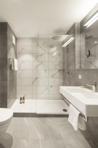ein Bad mit einer Dusche, einem Waschbecken und einem WC in der Unterkunft Hotel Schwanen in Köngen