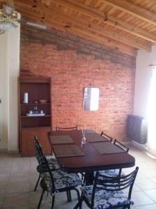 a table and chairs in a room with a brick wall at Departamentos Las Grutas Enjoy in Las Grutas