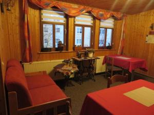 Zimmer mit einem Tisch, Stühlen und Fenstern in der Unterkunft Pension Stepponat in Arnstadt