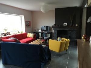 sala de estar con sofá rojo y sillas amarillas en VUE SEINE Chambre Panorama, en La Bouille