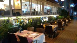 Un comedor con mesas y sillas y plantas. en Sunway Hotel, en Alanya