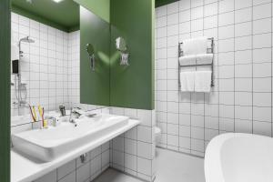 uma casa de banho branca com um lavatório e uma parede verde em City Hotel Bortoli by Ribas em Odessa