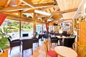 a restaurant with tables and chairs and windows at Hotel Les Bruyères in Morzine