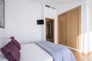 a bedroom with a white bed and a large window at Flatsforyou Port in Valencia