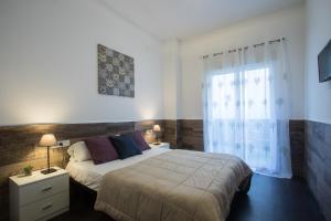 a bedroom with a large bed and a window at Flatsforyou Turia in Valencia