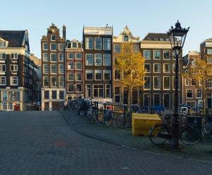 una fila de bicicletas estacionadas en una calle con edificios en 18th Century Groundfloor Canal House with patio/garden, en Ámsterdam